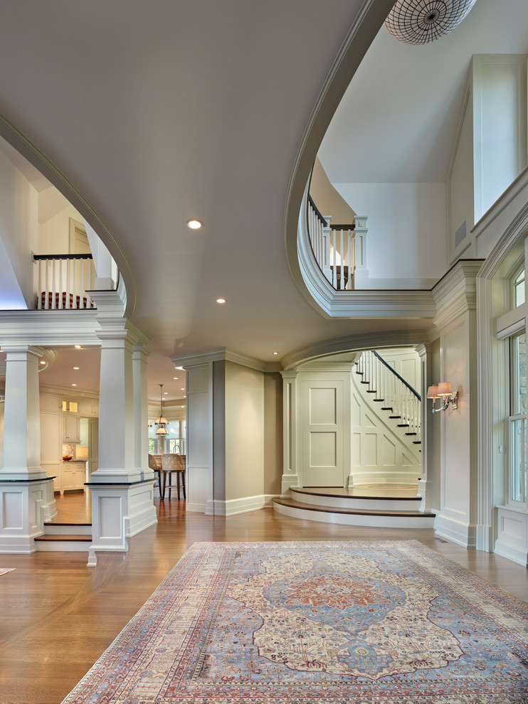 Photo of a large traditional foyer in Other with white walls, dark hardwood flooring, a single front door, a dark wood front door and brown floors.