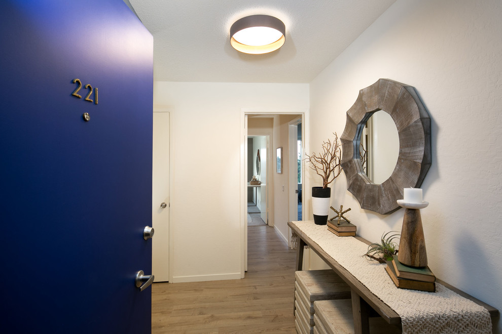 На фото: прихожая в современном стиле с белыми стенами, полом из ламината, одностворчатой входной дверью, синей входной дверью и бежевым полом