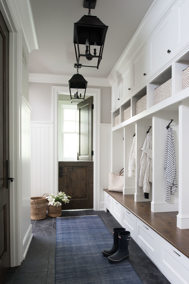 This is an example of a nautical hallway in Minneapolis with grey walls, a stable front door, a dark wood front door, grey floors and feature lighting.