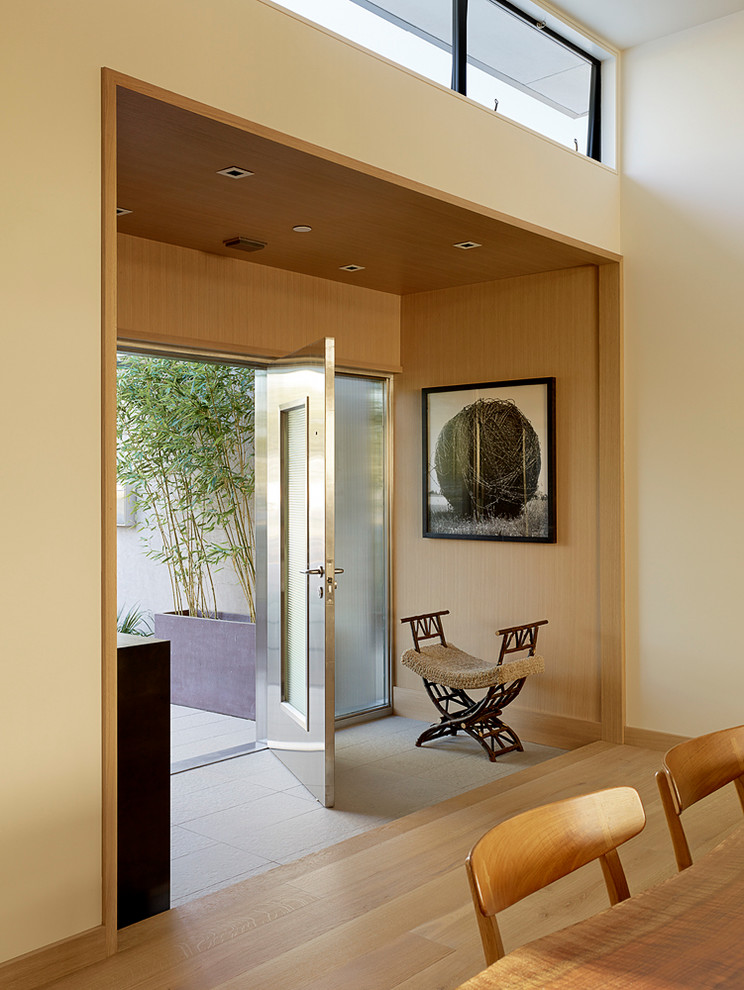 На фото: фойе среднего размера в стиле модернизм с белыми стенами, полом из керамогранита, одностворчатой входной дверью и металлической входной дверью с