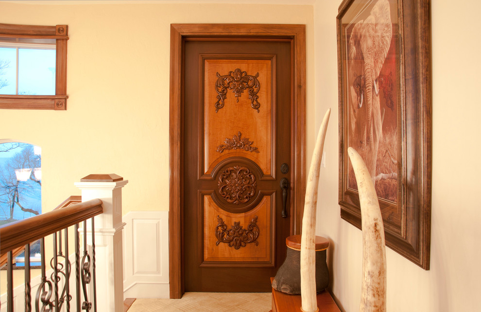 ニューヨークにある中くらいなヴィクトリアン調のおしゃれな玄関ドア (ベージュの壁、無垢フローリング、濃色木目調のドア) の写真
