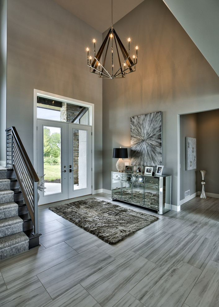 Inspiration for a contemporary front door in Omaha with a double front door, grey walls, a glass front door and feature lighting.