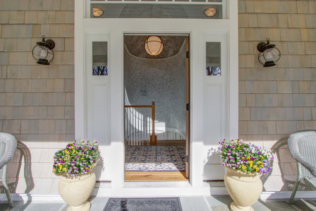 Immagine di una porta d'ingresso costiera di medie dimensioni con pareti beige, una porta singola e una porta in legno chiaro