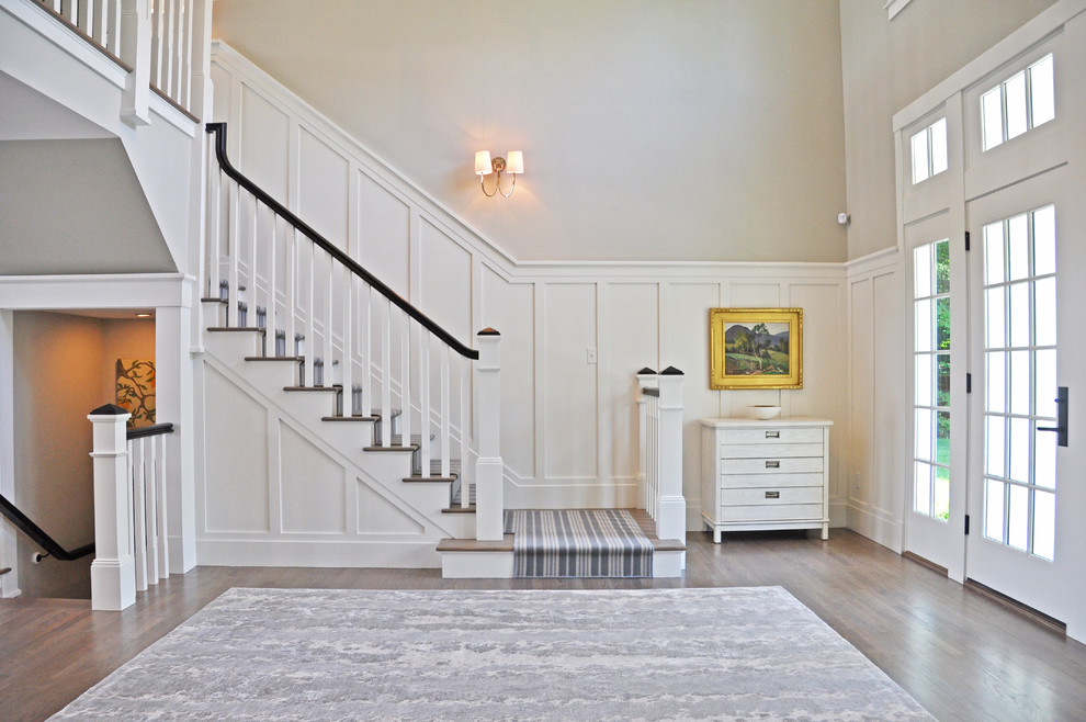 Example of a mid-sized classic medium tone wood floor and brown floor entryway design in Portland Maine with gray walls and a glass front door