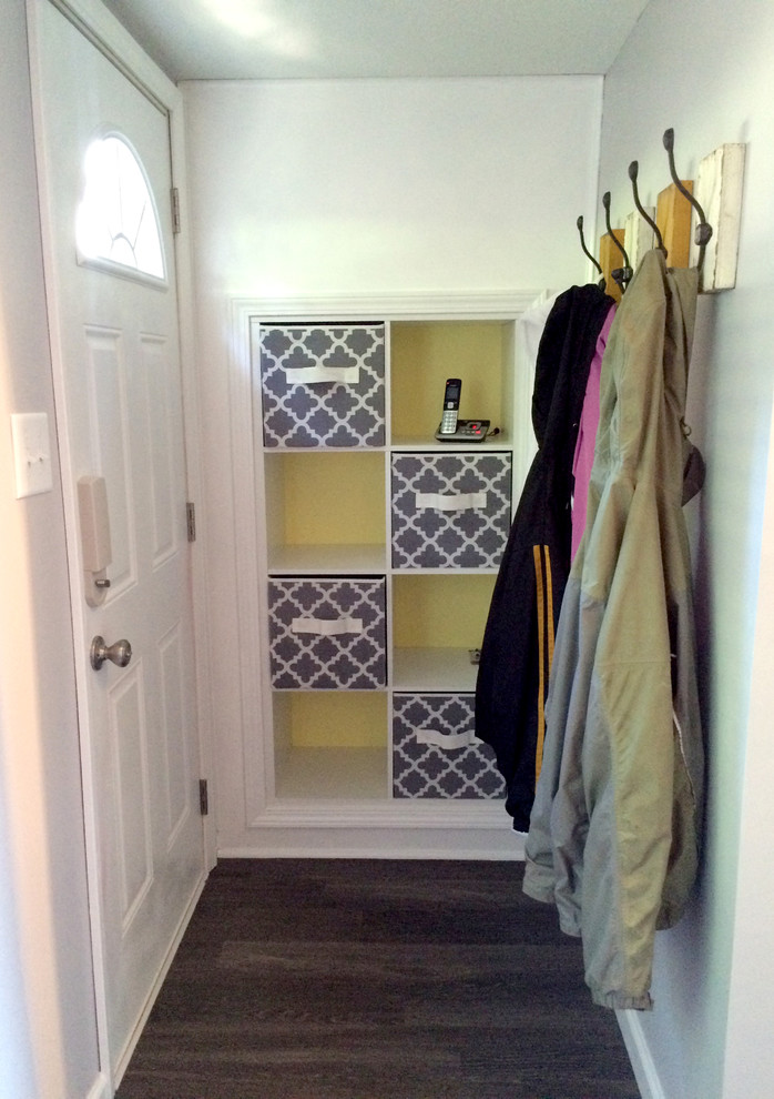 Kleines Modernes Foyer mit grauer Wandfarbe, braunem Holzboden, Einzeltür und weißer Haustür in Sonstige