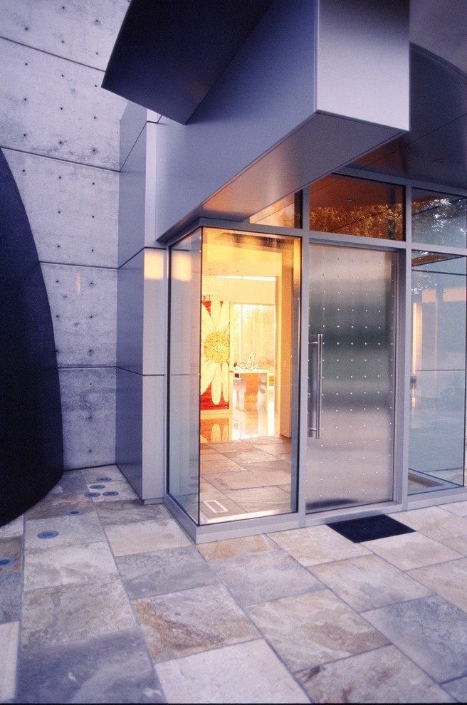 Стильный дизайн: огромная входная дверь в стиле модернизм с белыми стенами, гранитным полом, одностворчатой входной дверью и металлической входной дверью - последний тренд