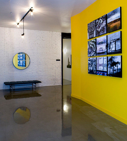 Photo of a large urban front door in San Francisco with yellow walls and concrete flooring.