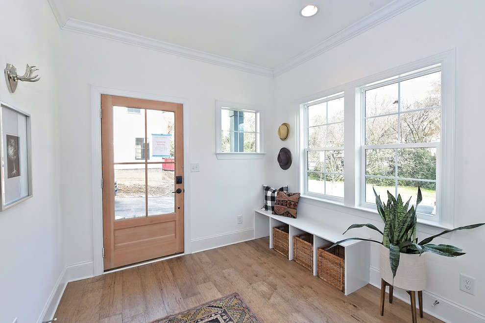Ejemplo de hall de estilo de casa de campo con paredes blancas, suelo de madera en tonos medios, puerta simple, puerta de madera en tonos medios y suelo marrón
