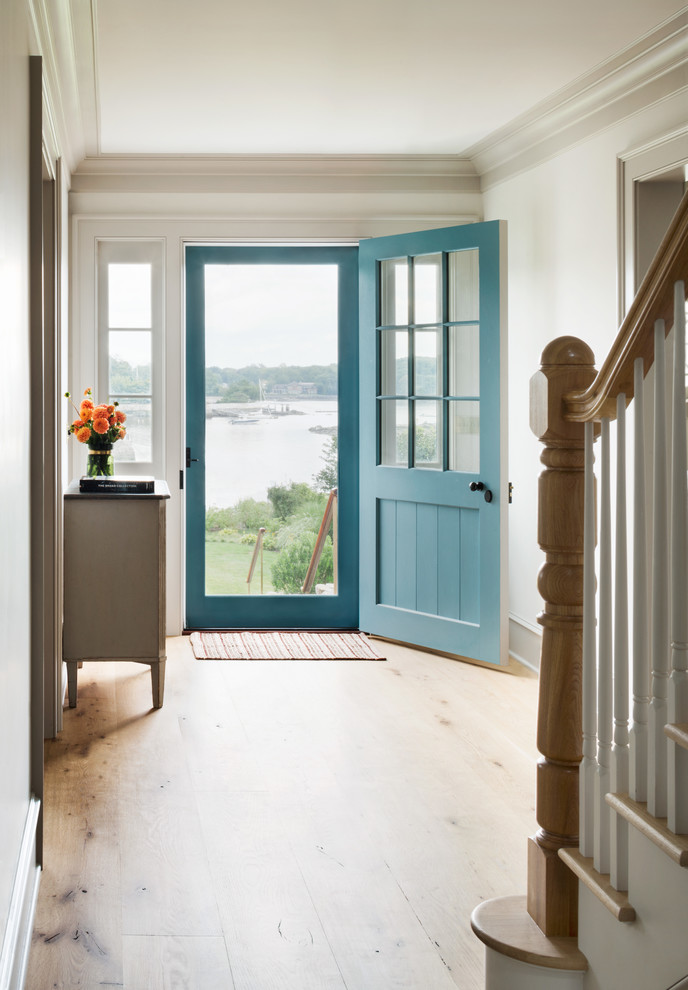 На фото: фойе в морском стиле с белыми стенами, светлым паркетным полом, одностворчатой входной дверью и синей входной дверью с