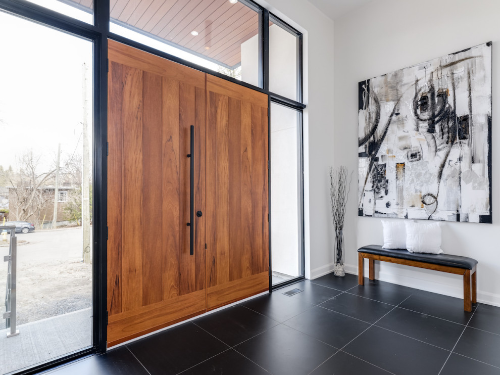 Ispirazione per un grande ingresso minimal con pavimento in legno massello medio, una porta marrone e pavimento grigio