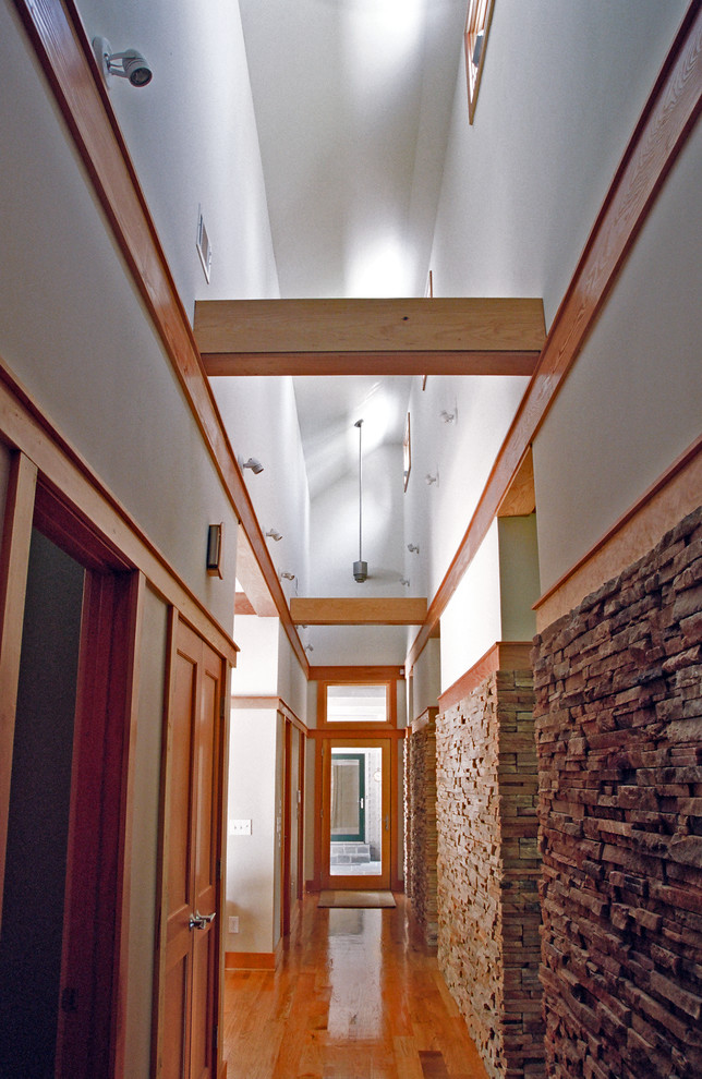 Example of a large trendy medium tone wood floor entryway design in Atlanta with white walls and a light wood front door