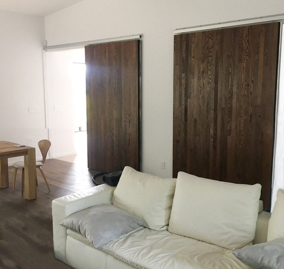 Ejemplo de puerta principal minimalista grande con paredes grises, moqueta, puerta corredera, puerta gris y suelo beige