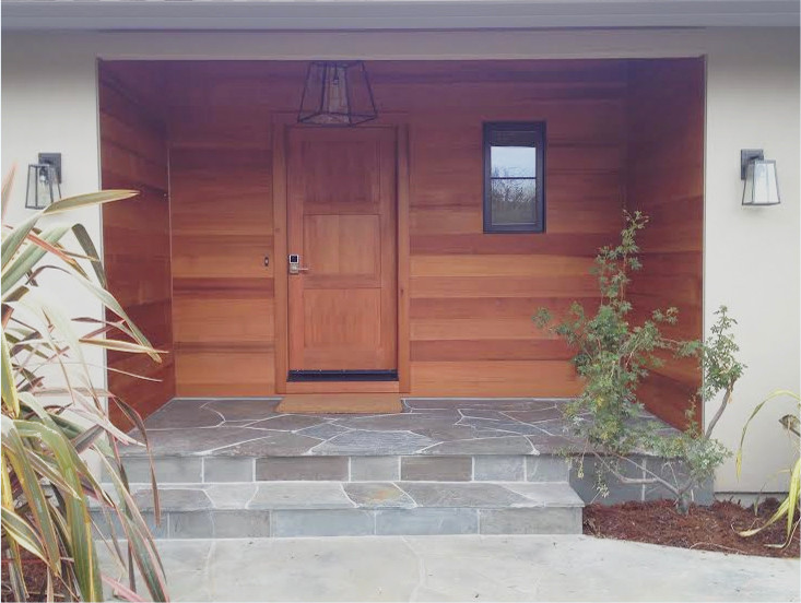 Esempio di una porta d'ingresso minimalista di medie dimensioni con una porta singola, una porta in legno bruno e pareti marroni