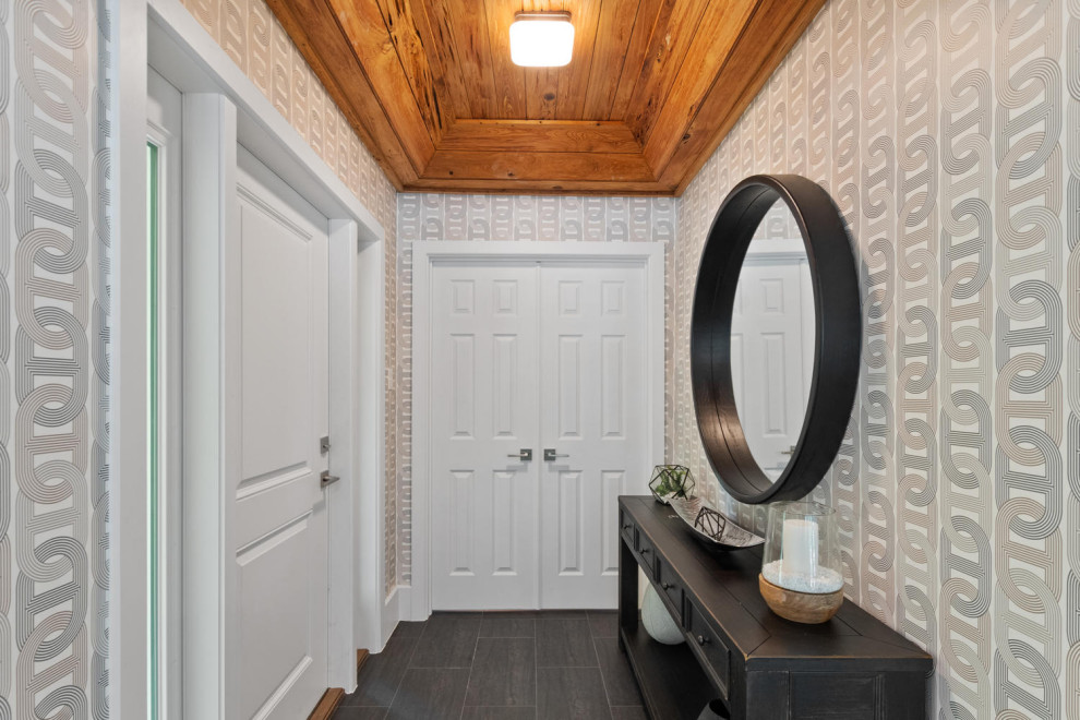 Ejemplo de distribuidor bohemio pequeño con paredes multicolor, suelo de madera oscura, puerta simple, puerta blanca, suelo negro, madera y papel pintado