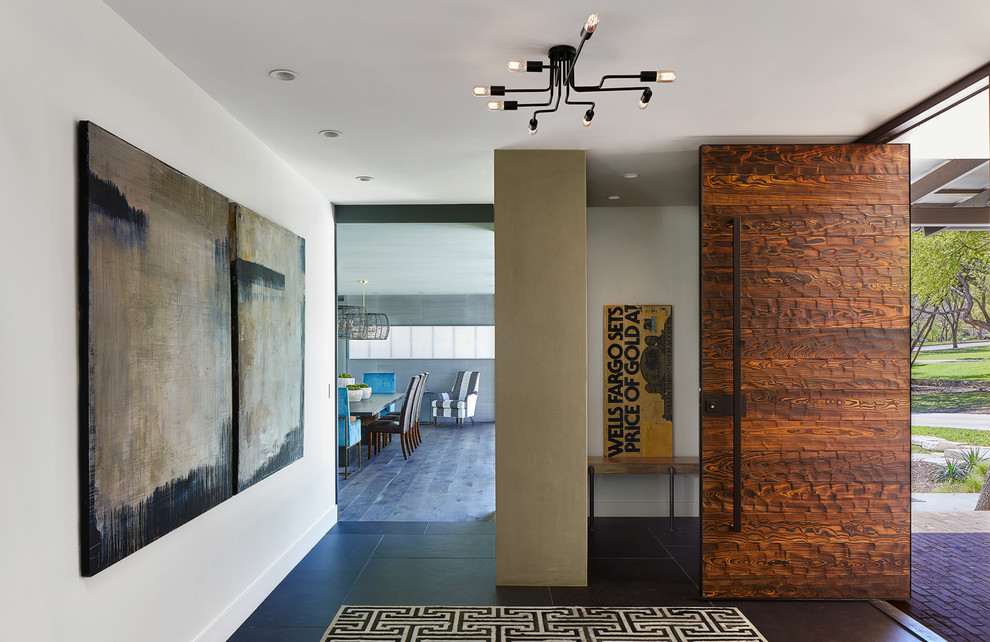 Entryway - industrial slate floor and black floor entryway idea in Austin with white walls and a dark wood front door