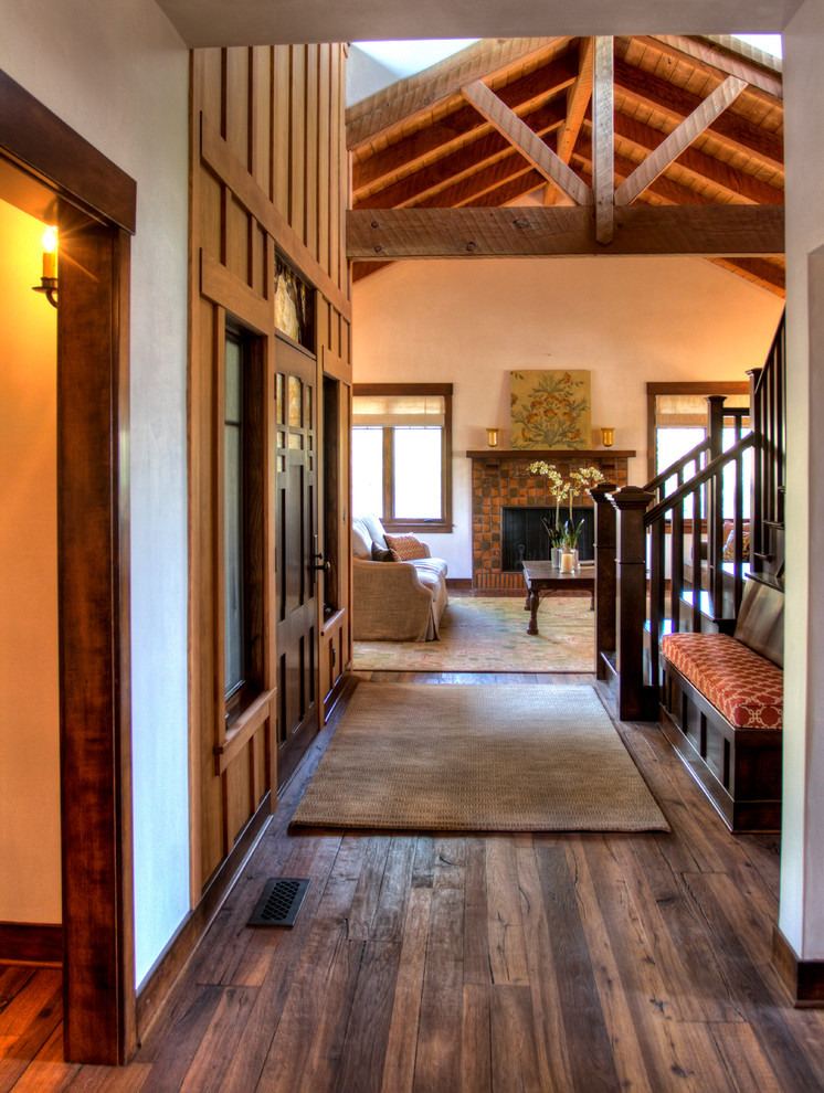 Example of an arts and crafts medium tone wood floor entryway design in Santa Barbara with white walls and a dark wood front door