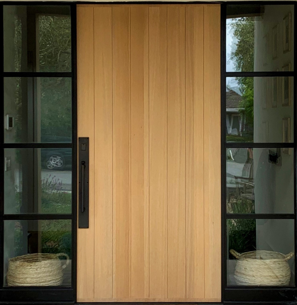 Immagine di una grande porta d'ingresso design con una porta singola e una porta in legno chiaro