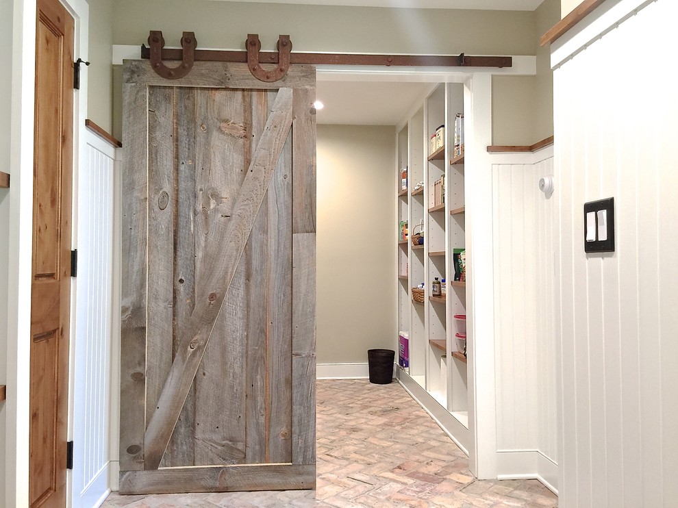 Réalisation d'une entrée tradition de taille moyenne avec un vestiaire, un mur beige, un sol en brique, une porte simple et une porte en bois foncé.