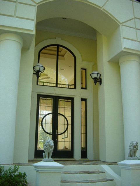 Imagen de puerta principal mediterránea grande con puerta doble y puerta de vidrio