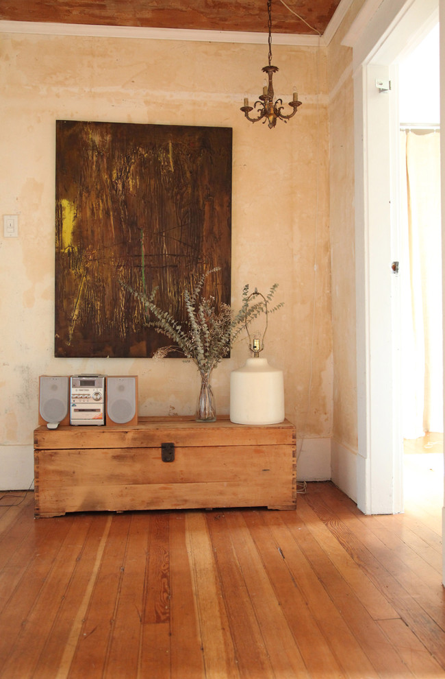Ejemplo de entrada ecléctica con paredes beige y suelo de madera en tonos medios