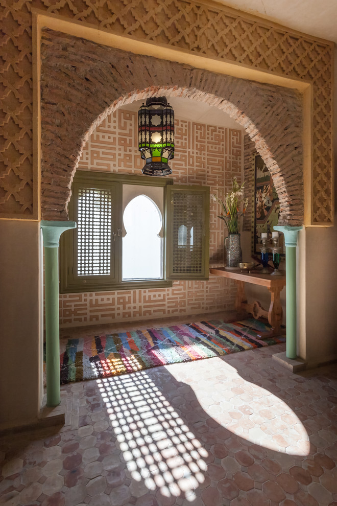 На фото: фойе в средиземноморском стиле с разноцветными стенами и полом из терракотовой плитки с