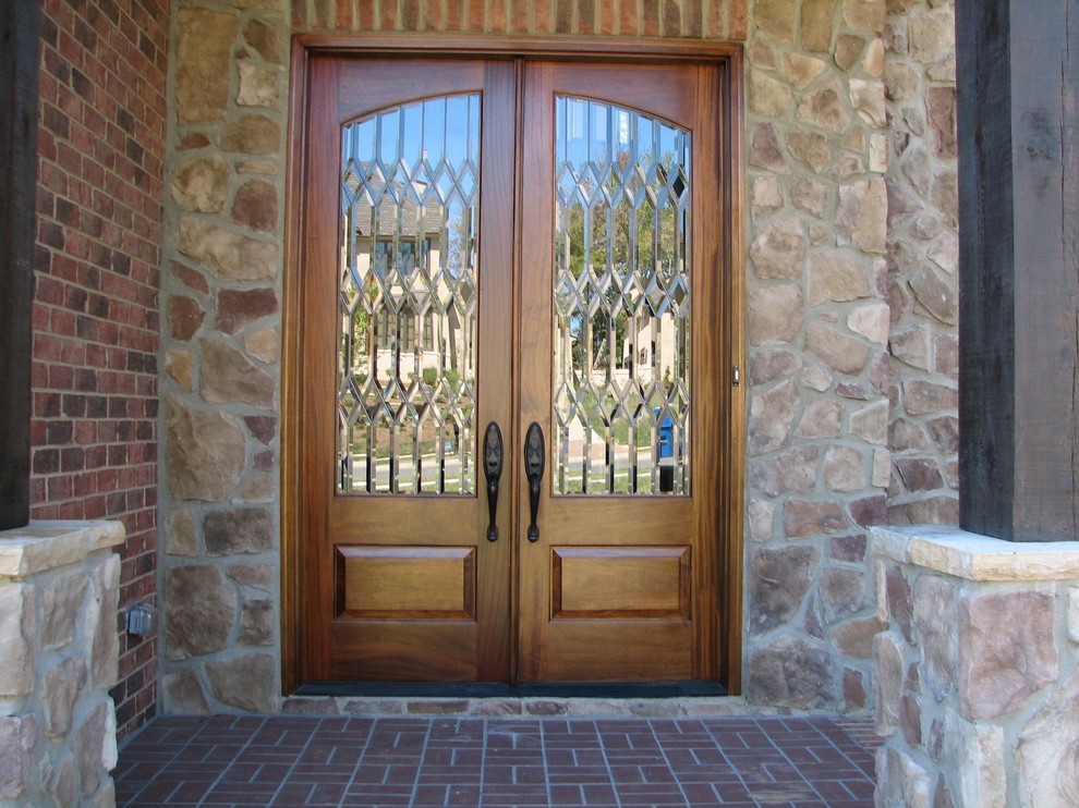 Inspiration pour une porte d'entrée traditionnelle avec une porte double et une porte en bois brun.