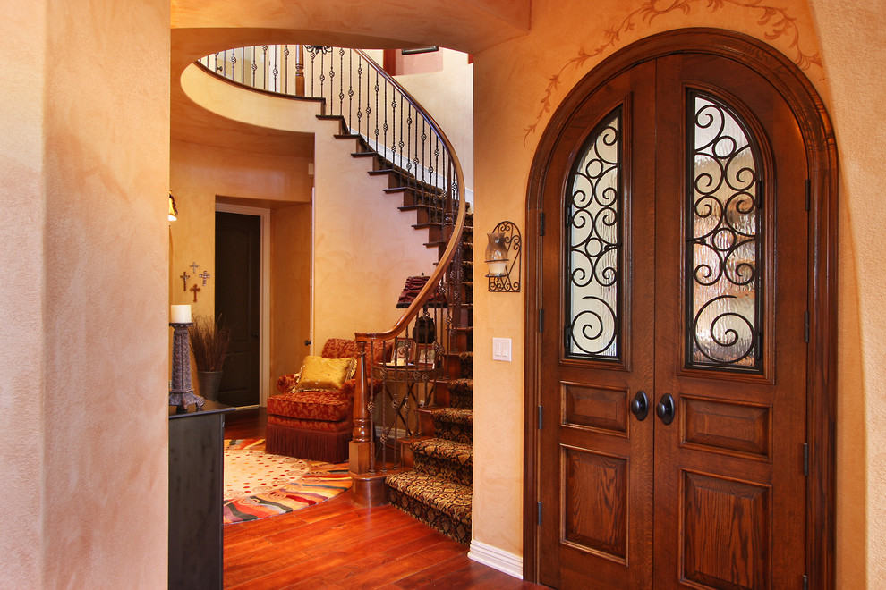 Eclectic dark wood floor entryway photo in San Diego with beige walls and a dark wood front door