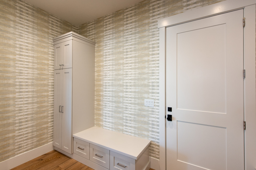ソルトレイクシティにある高級な中くらいなトランジショナルスタイルのおしゃれなマッドルーム (白い壁、淡色無垢フローリング、白いドア、茶色い床) の写真
