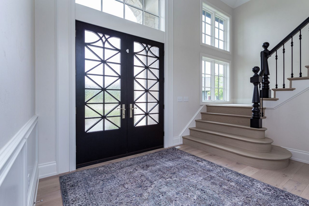 Idee per un ingresso o corridoio con pareti bianche, parquet chiaro, una porta a due ante, una porta nera e pannellatura