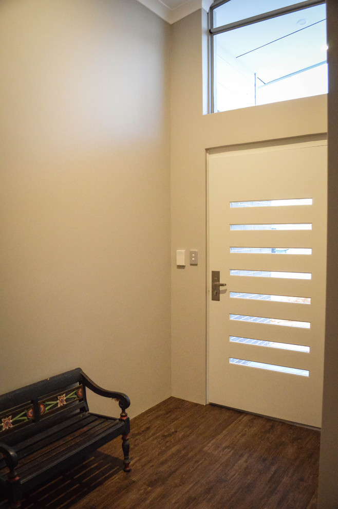 Idee per un ingresso minimalista con pavimento in vinile, una porta singola e una porta bianca