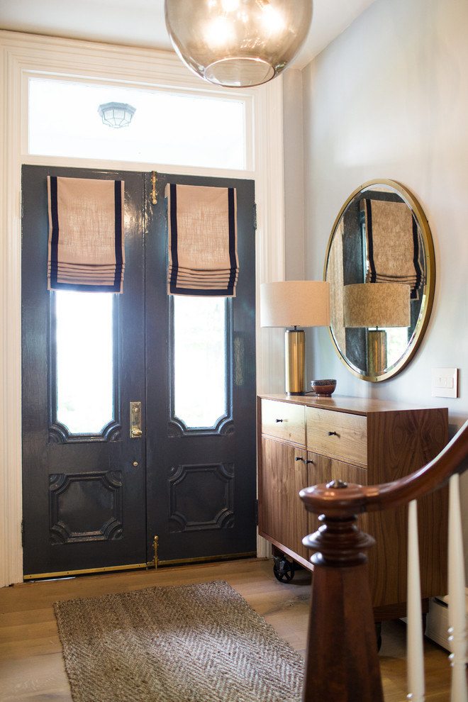 Idee per un piccolo ingresso con vestibolo stile marino con pareti beige, parquet chiaro, una porta a due ante e una porta nera