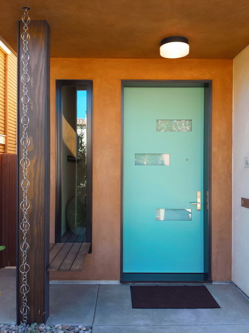 Imagen de puerta principal minimalista con suelo de madera en tonos medios, puerta azul y paredes blancas
