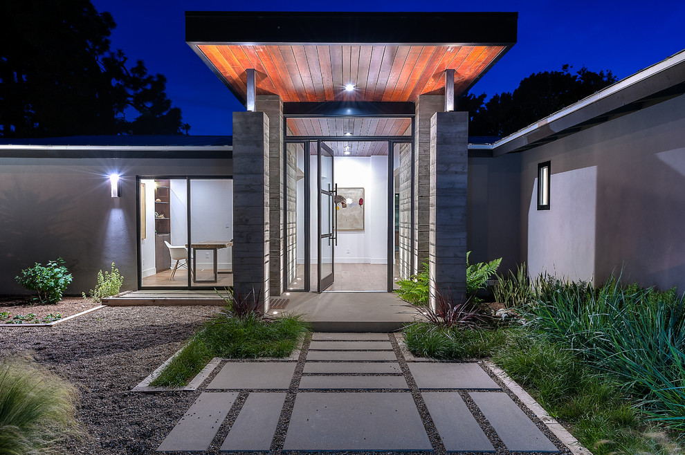 Mittelgroße Moderne Haustür mit Drehtür, Haustür aus Glas, grauer Wandfarbe und Betonboden in San Diego