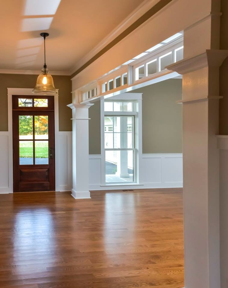 Immagine di un ingresso o corridoio classico con pareti beige, parquet chiaro, una porta singola e una porta in legno bruno