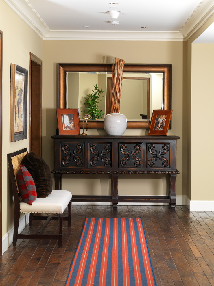 Example of a large mountain style medium tone wood floor foyer design in Orange County with beige walls