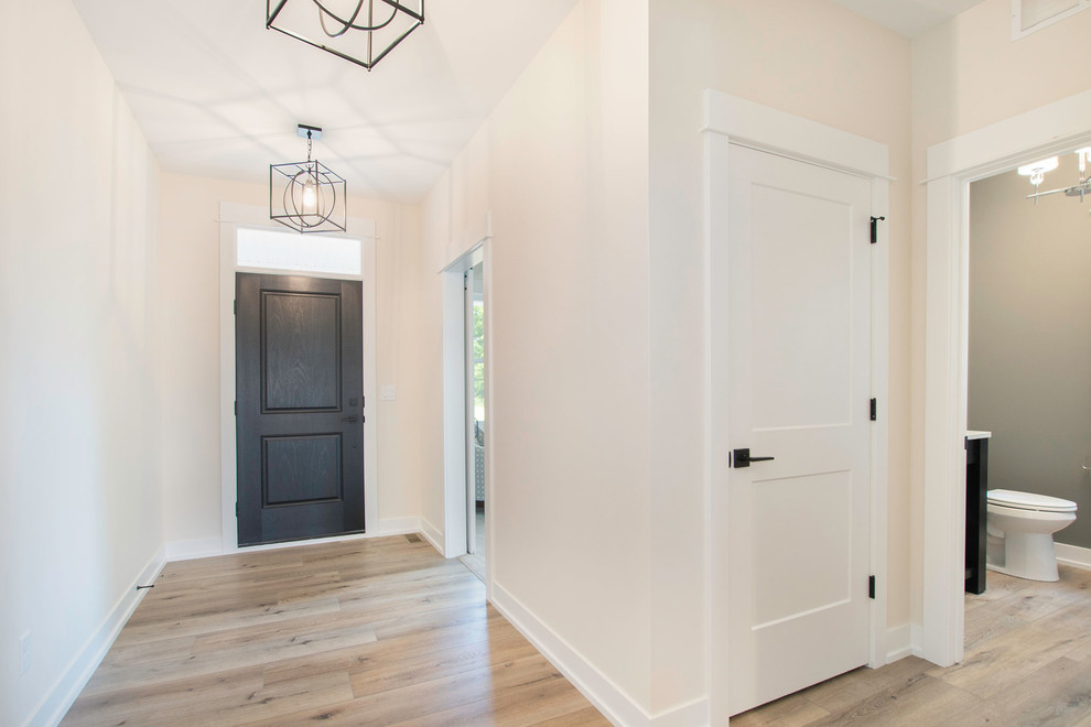 Mittelgroße Klassische Haustür mit weißer Wandfarbe, Vinylboden, Einzeltür, schwarzer Haustür und braunem Boden in Grand Rapids
