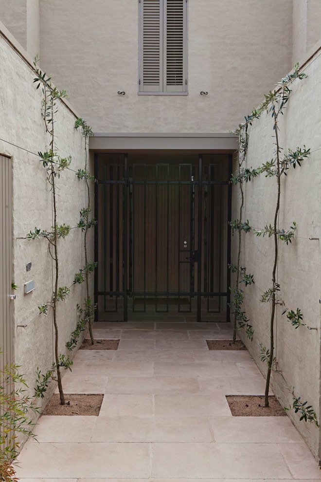 Idee per una grande porta d'ingresso minimal con pavimento in pietra calcarea