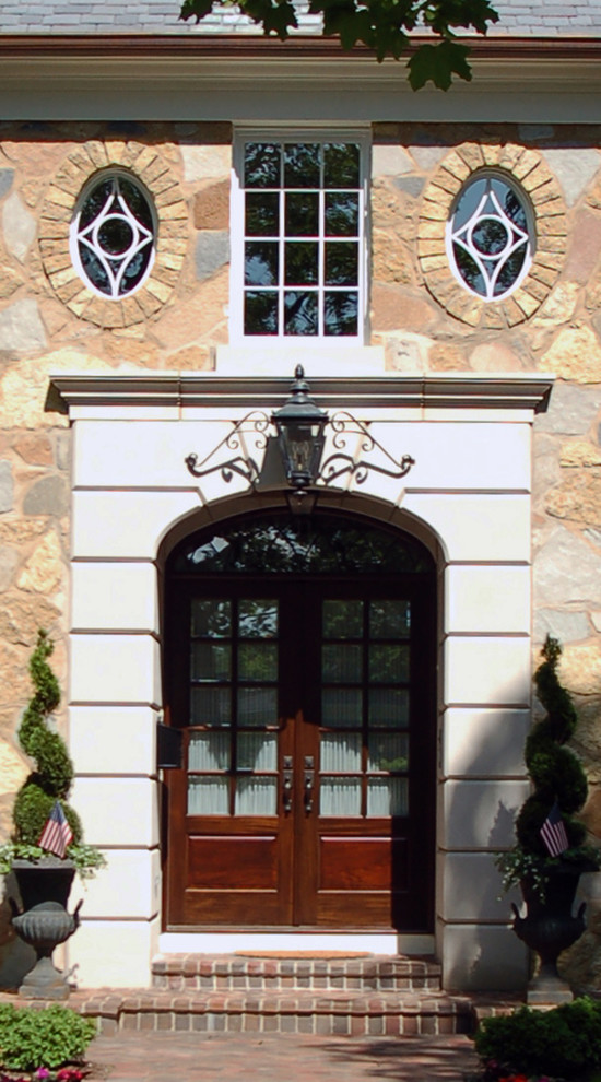 Aménagement d'une porte d'entrée classique de taille moyenne avec une porte double et une porte en bois foncé.
