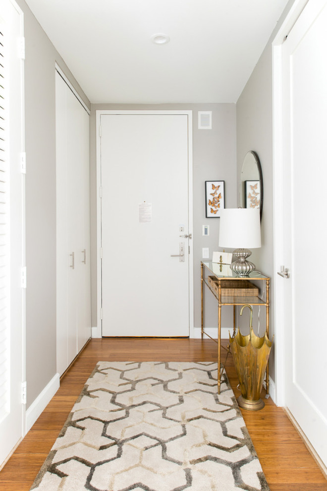 Diseño de hall retro pequeño con paredes grises, suelo de madera en tonos medios, puerta simple y puerta blanca