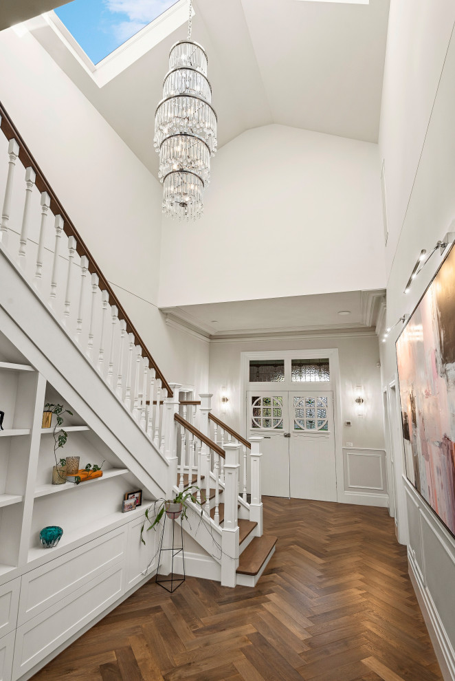 Esempio di un grande corridoio vittoriano con pareti bianche, pavimento in legno massello medio, una porta a due ante, una porta in legno chiaro, pavimento marrone e soffitto in legno