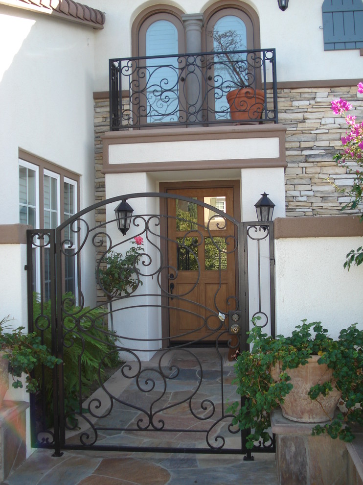 Источник вдохновения для домашнего уюта: маленькая входная дверь в средиземноморском стиле с одностворчатой входной дверью и входной дверью из дерева среднего тона для на участке и в саду