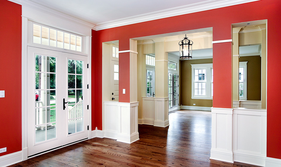 На фото: большое фойе в классическом стиле с красными стенами, паркетным полом среднего тона, одностворчатой входной дверью и белой входной дверью с