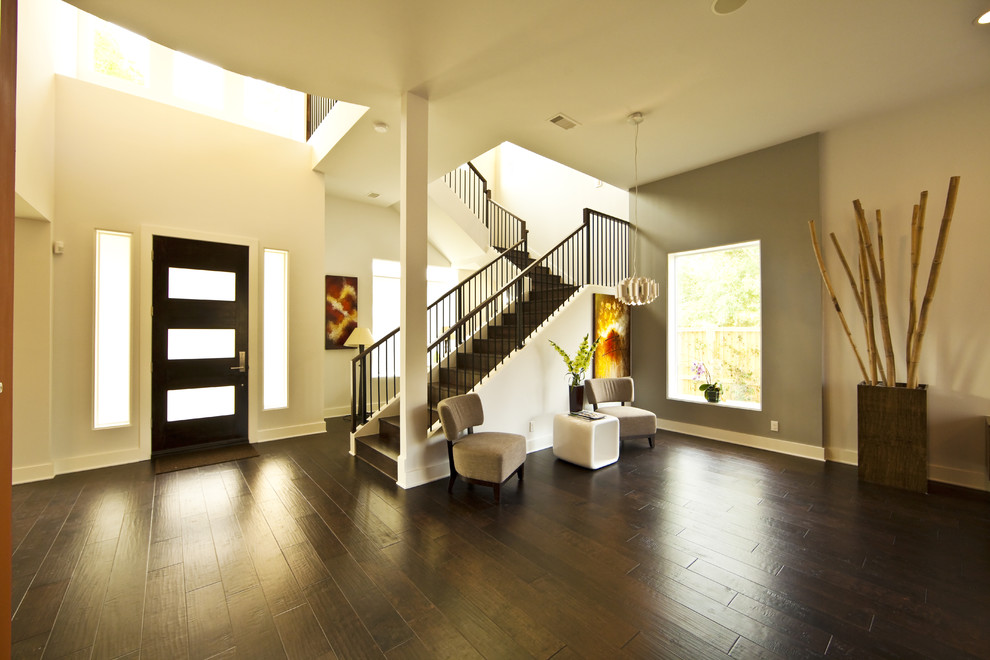Entryway - mid-sized contemporary dark wood floor and brown floor entryway idea in Houston with white walls and a black front door
