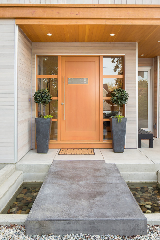 Contemporary front door in Vancouver with a single front door and a light wood front door.