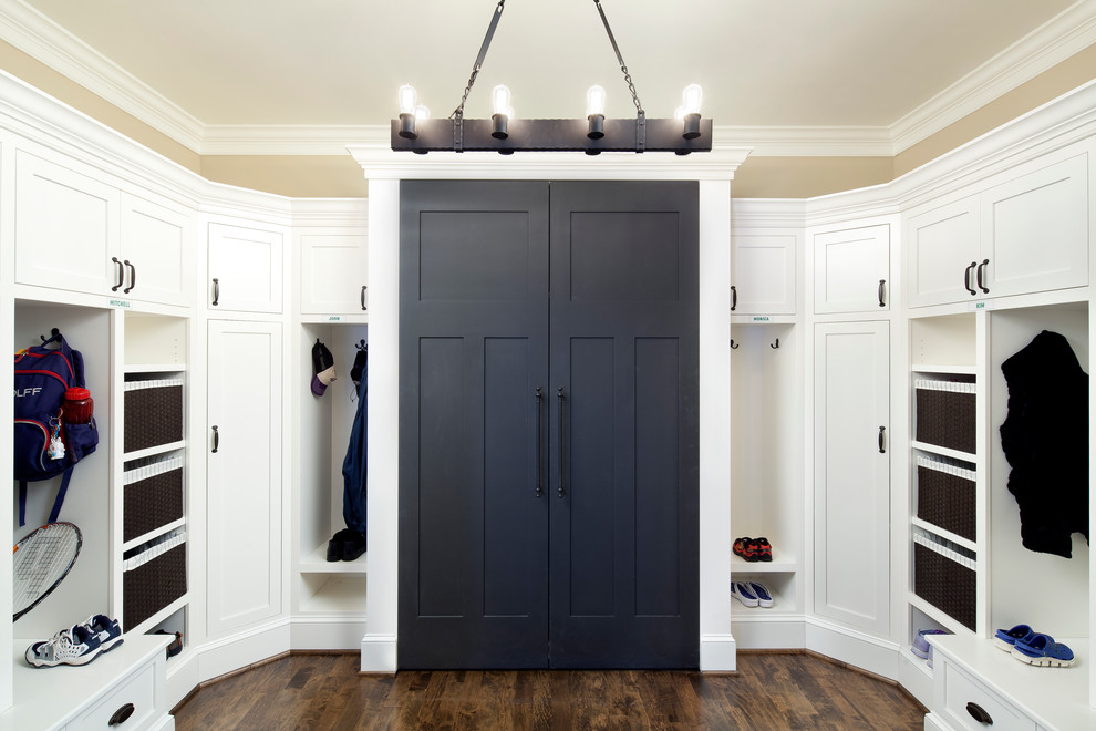 Inspiration for a large timeless medium tone wood floor mudroom remodel in Baltimore with beige walls