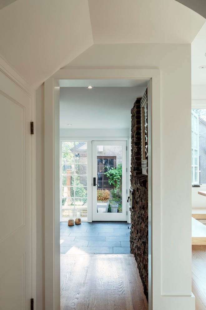 Example of a trendy entryway design in Boston with white walls and a white front door