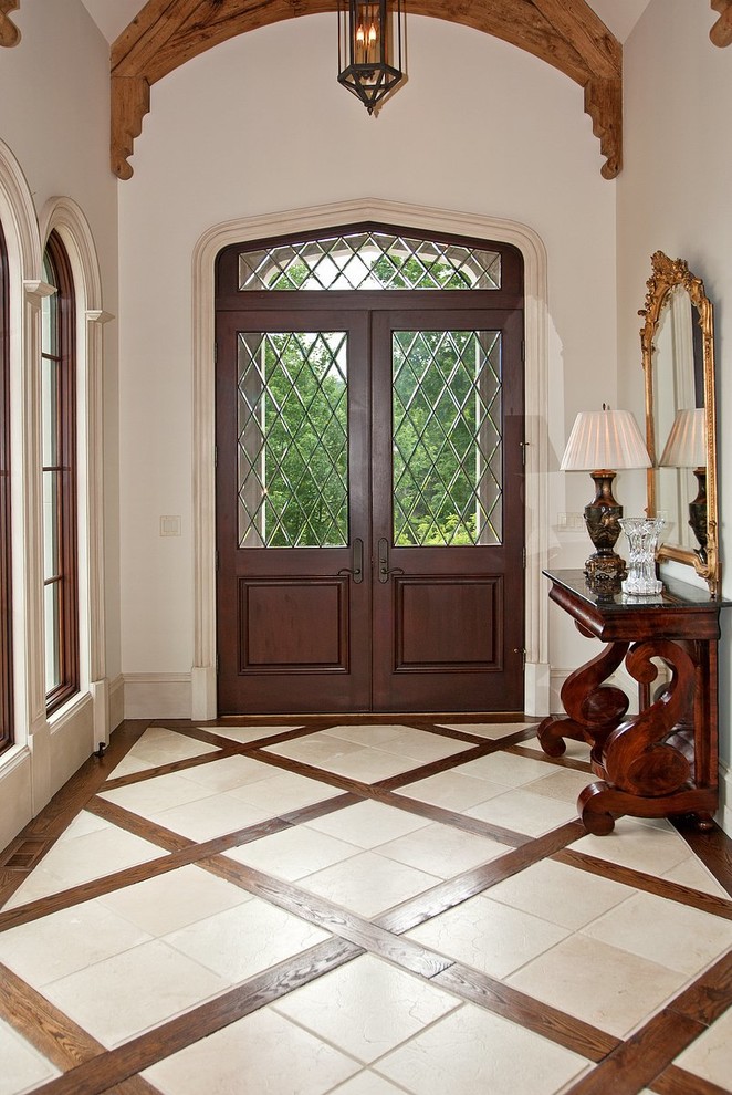 Inspiration pour un hall d'entrée traditionnel avec un mur blanc, une porte double, une porte en verre et un sol en travertin.