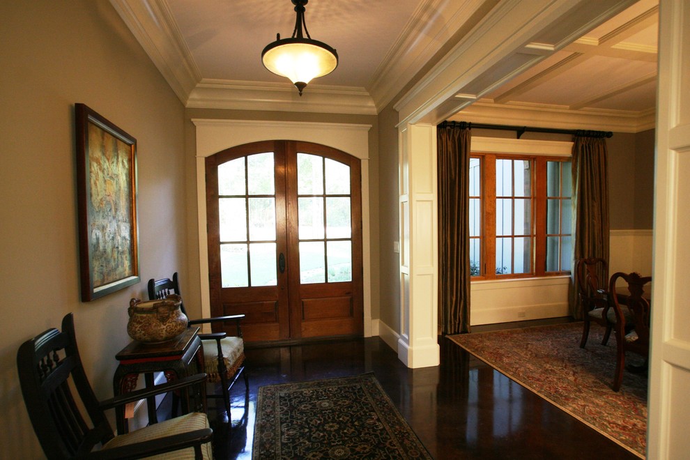 Exemple d'un hall d'entrée craftsman avec un mur beige, une porte double et une porte en bois foncé.