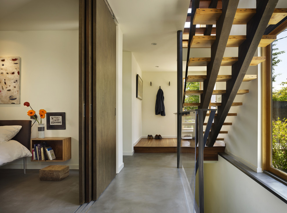 На фото: фойе среднего размера в стиле модернизм с белыми стенами, бетонным полом, одностворчатой входной дверью и входной дверью из дерева среднего тона