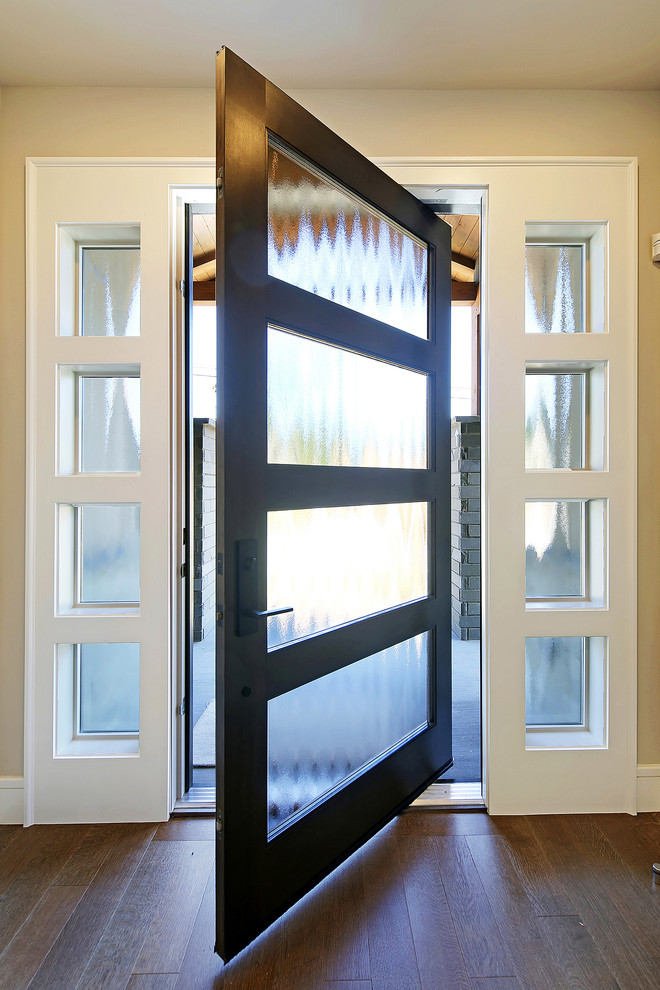 Inspiration for a medium sized contemporary front door in Seattle with beige walls, dark hardwood flooring, a pivot front door and a black front door.